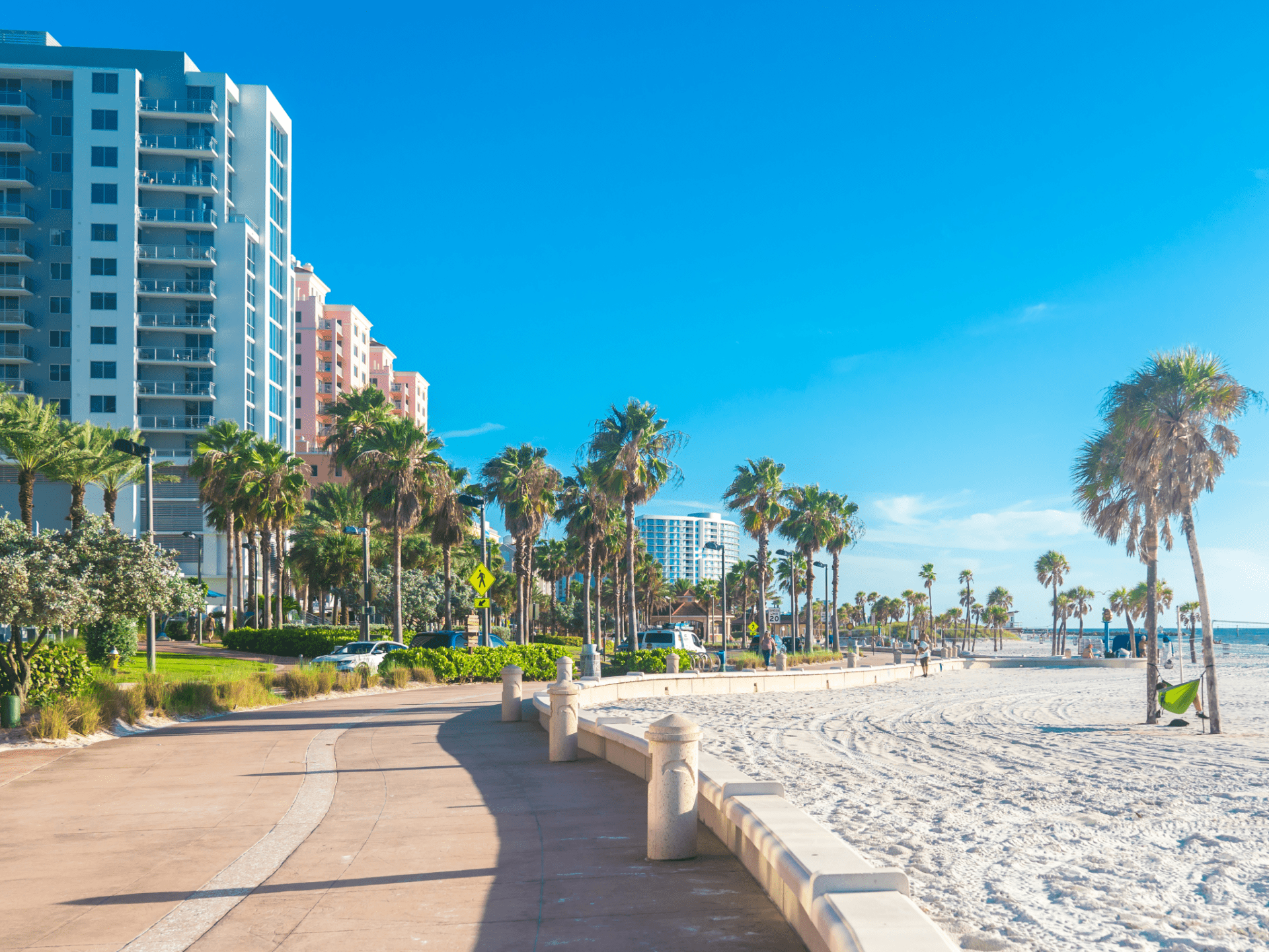 a beach with palm trees and buildings